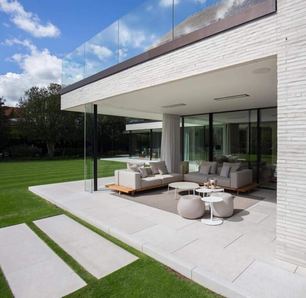 Modern outdoor spacious alfresco area with cream lounge setting and electric heaters