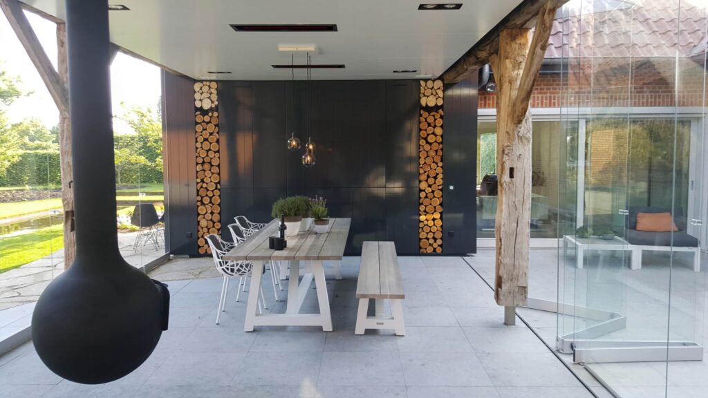 Modern alfresco area featuring suspended gas fireplace, wooden furnishings and electric heaters