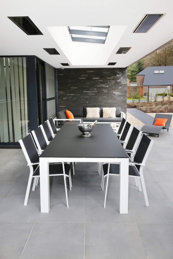 Black eight seater table in outdoor alfresco area with sky roof and flush heating in roof